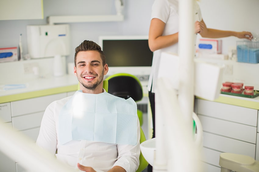 Anxiety free male patient awaits his hygiene checkup with a dental hygienist. Without him taking control of his anxiety he might be undiagnosed with gum disease or a cavity
