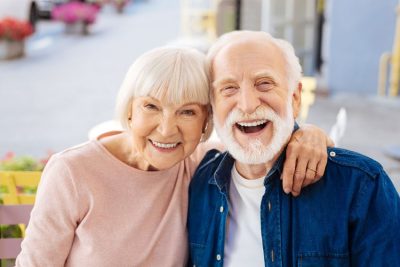 senior couple hugging and smiling on bench